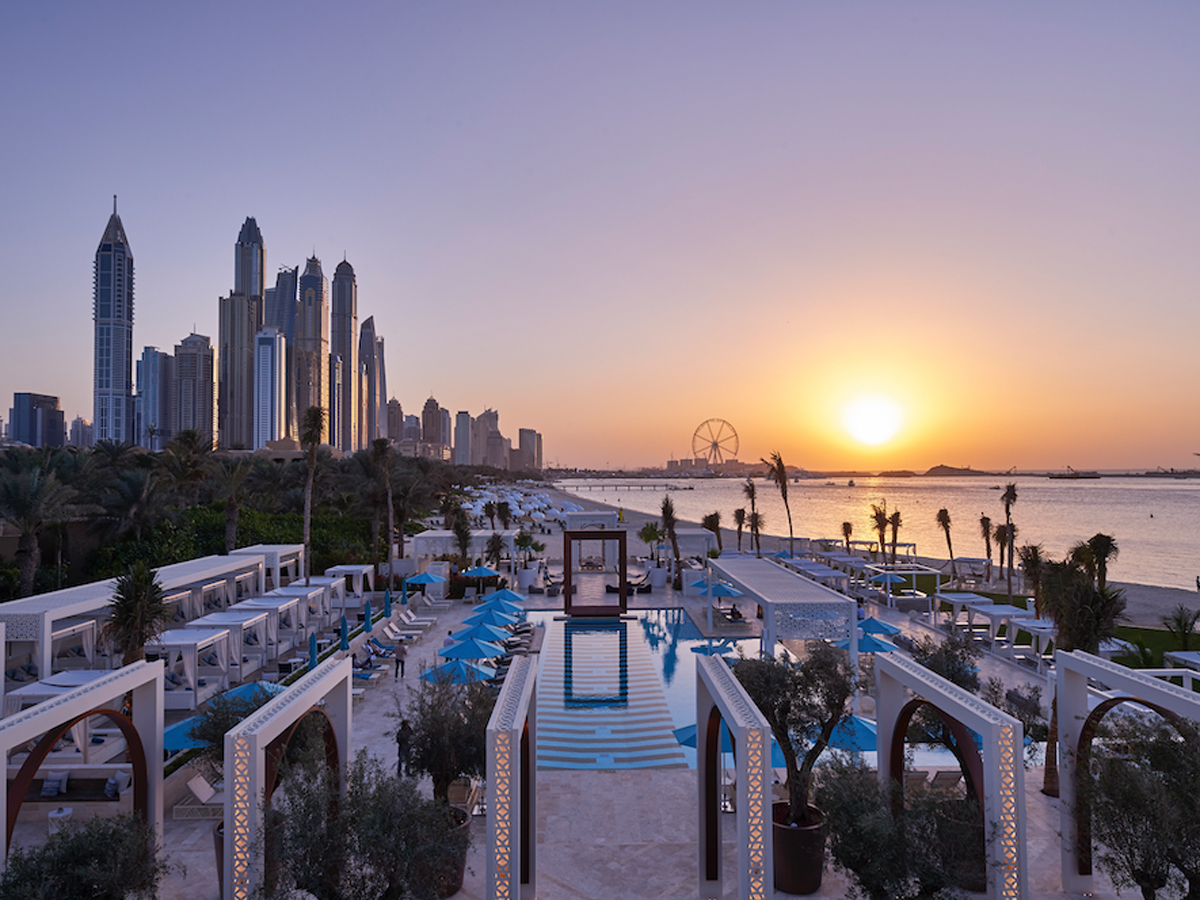 Luxury beach club in Dubai with infinity pool and skyline view at sunset